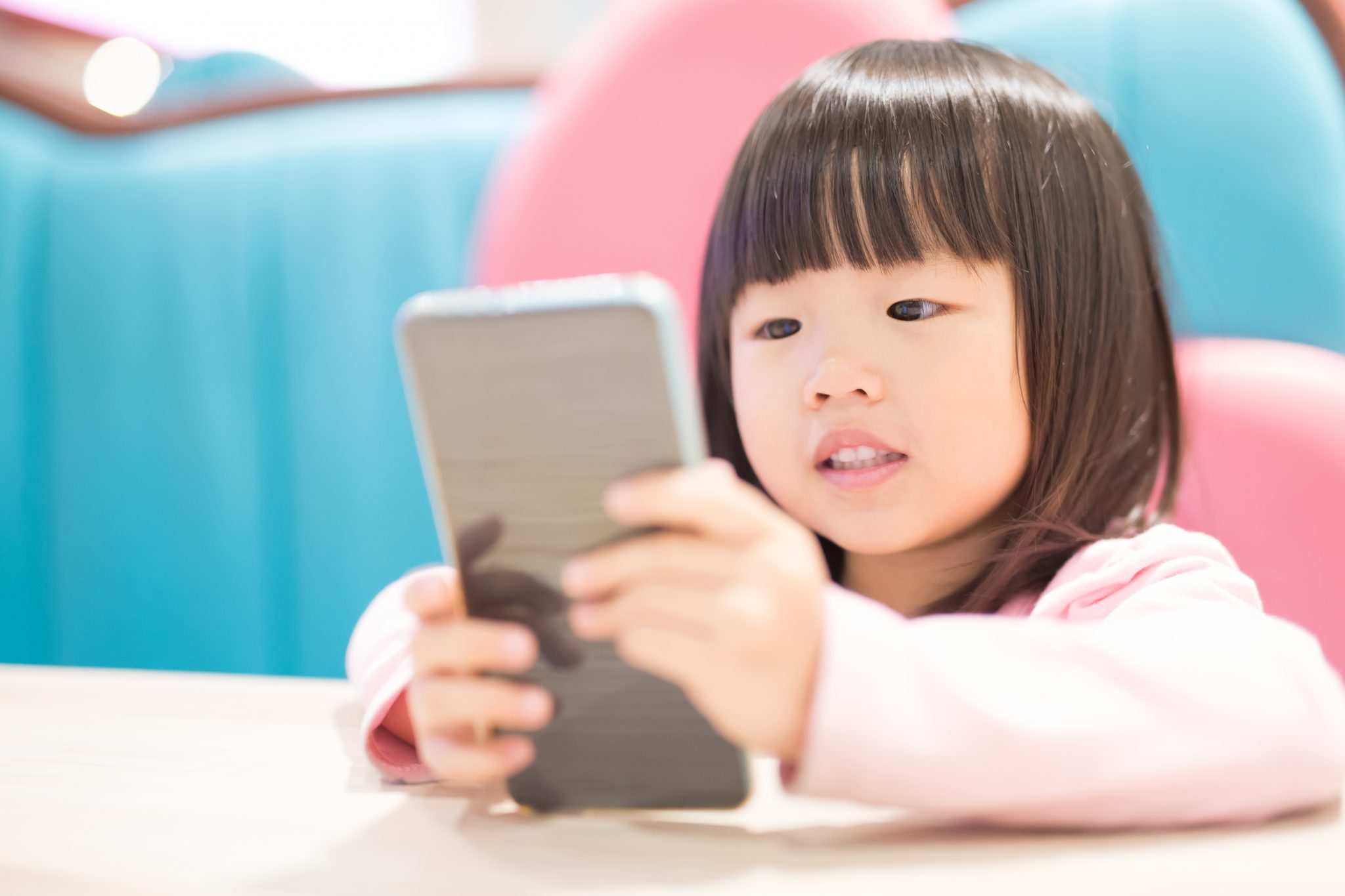 A happy baby girl holding phone in her hand