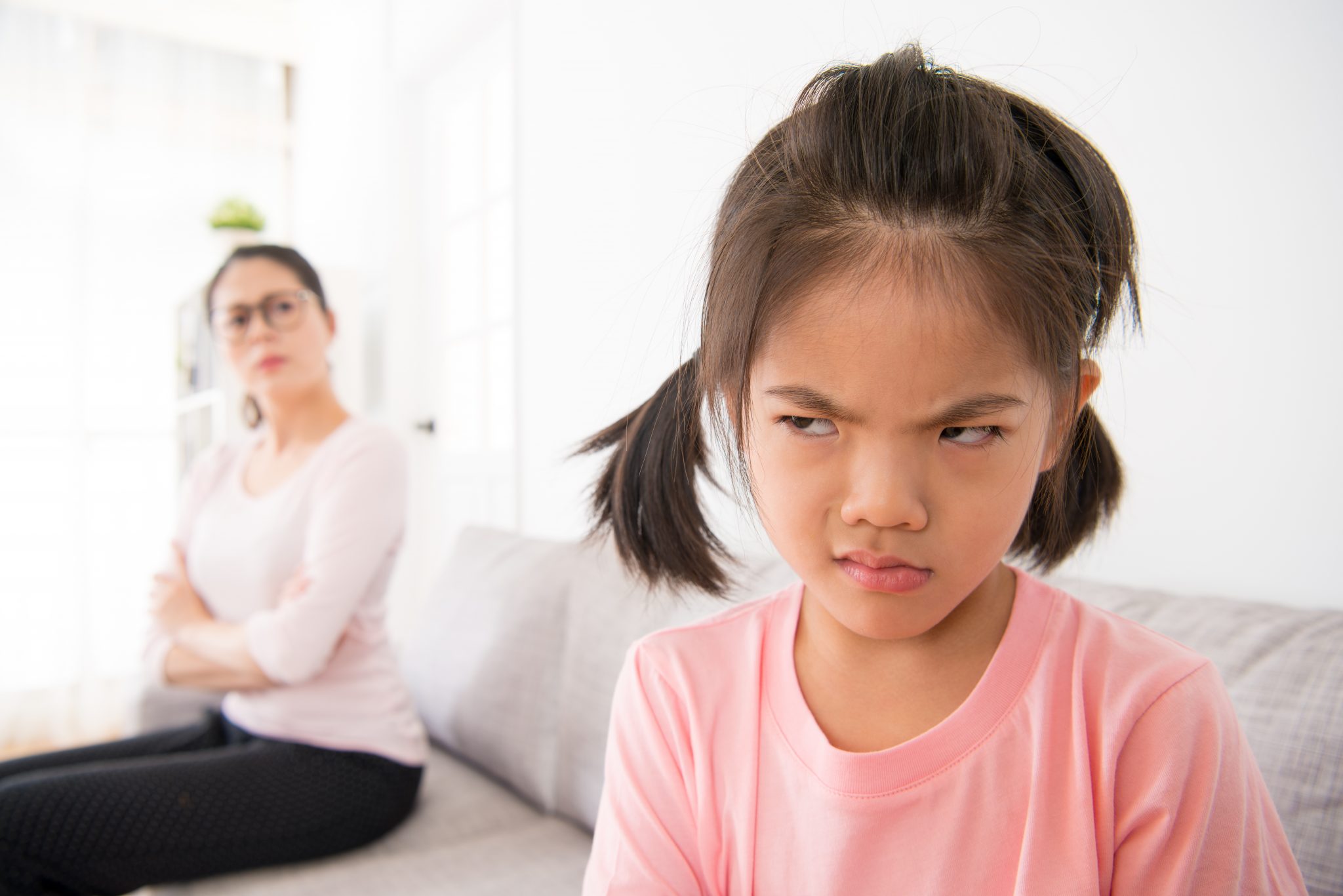 A female kid throwing a stressed expression to her mother