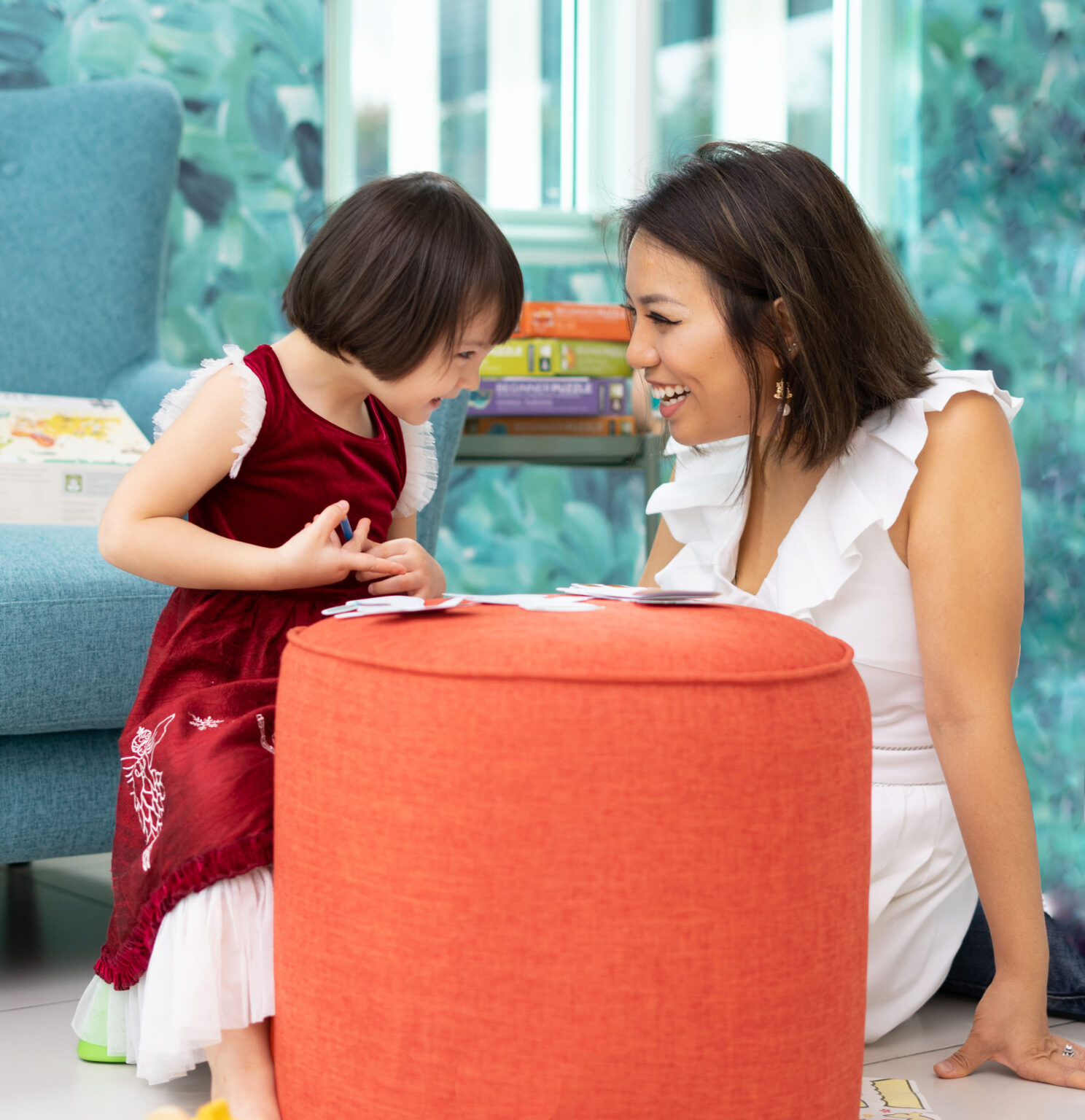 a mother and her female baby child looking and laughing at each other