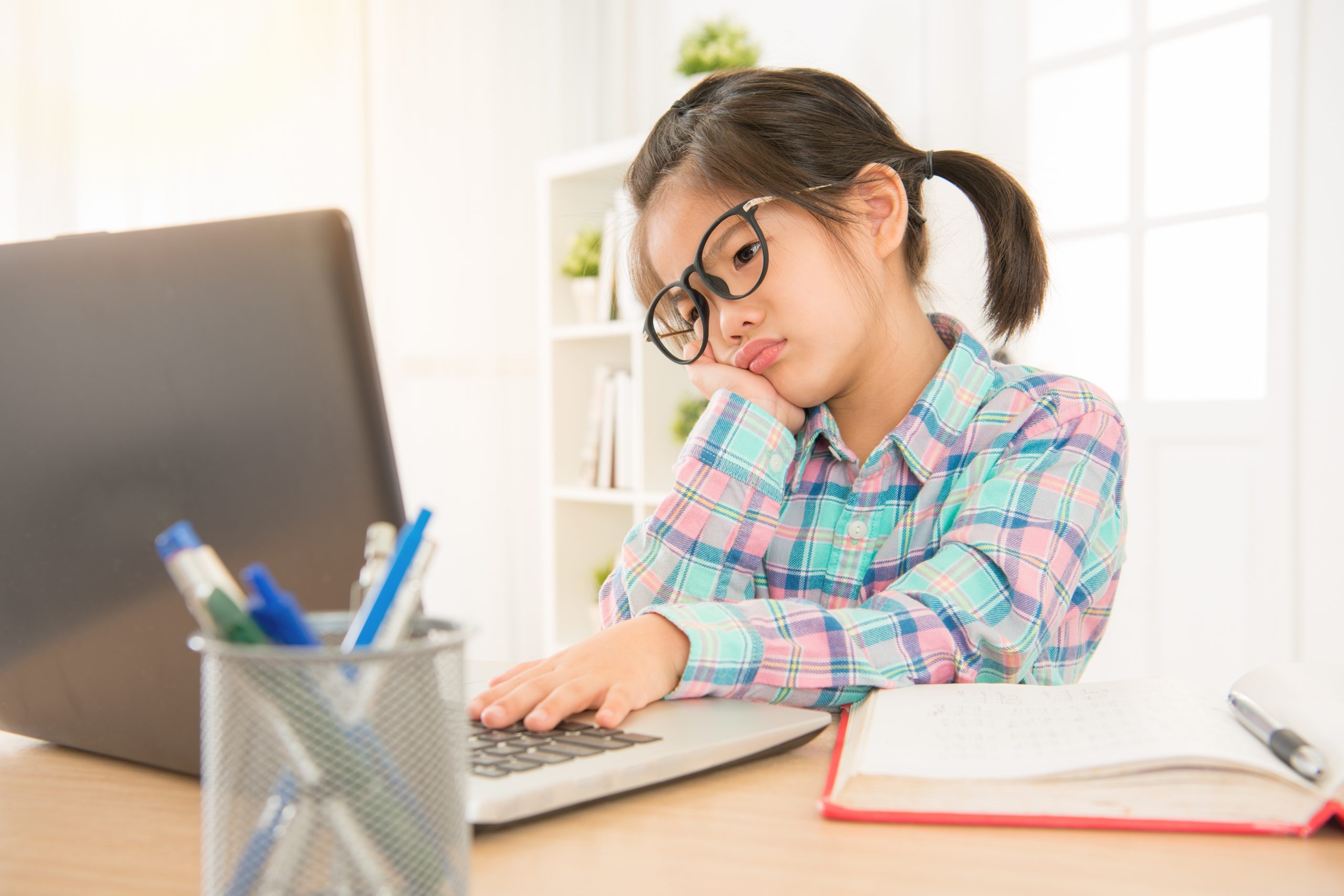 An worried female child looking at a laptop screen