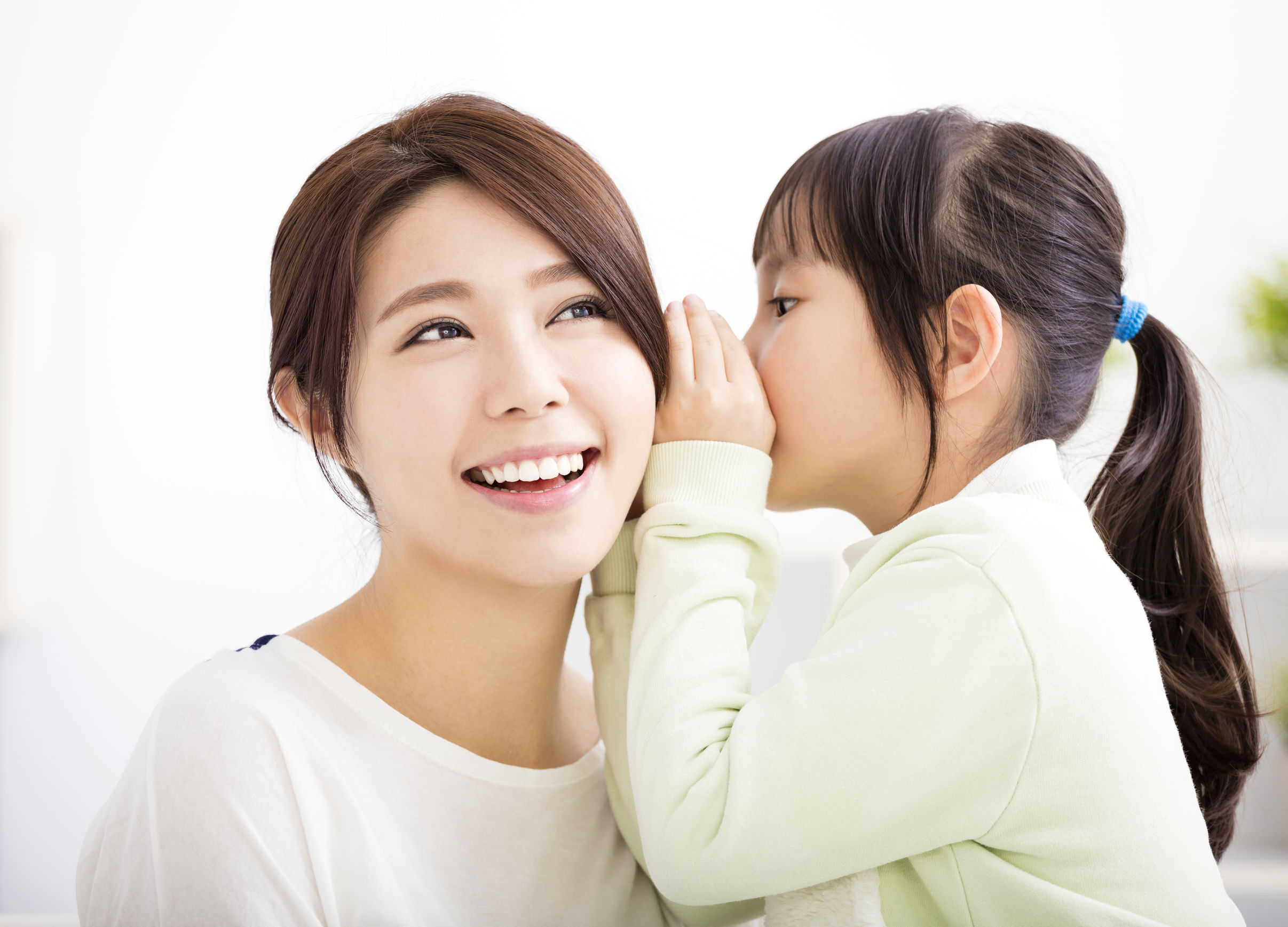 A baby girl whispering with her mother