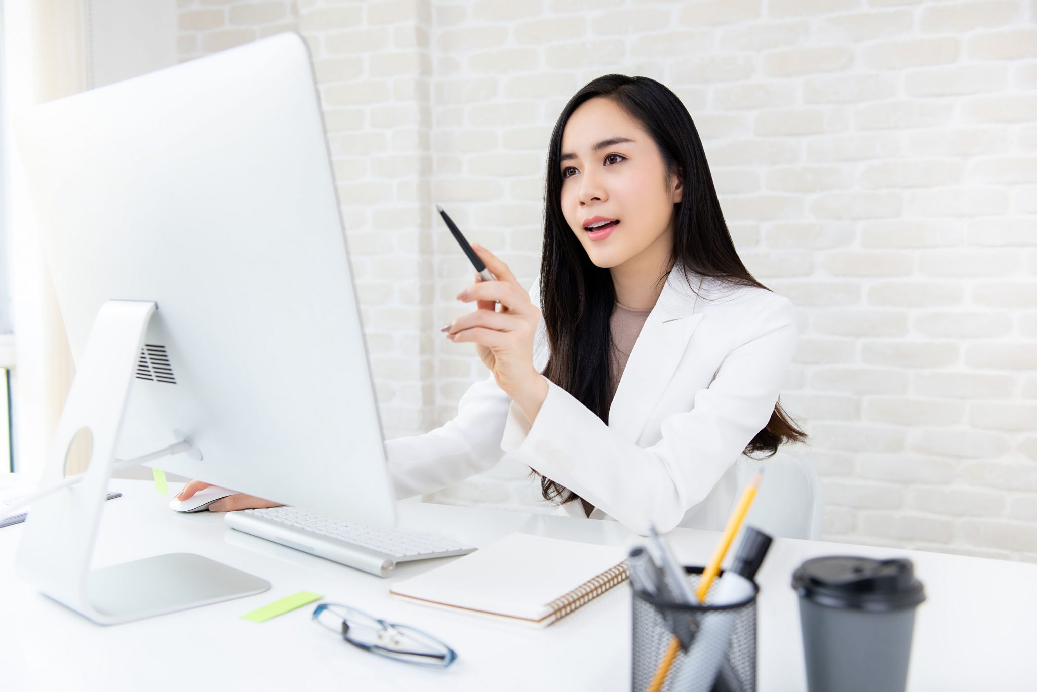 A female employee working on her desktop screen in a office