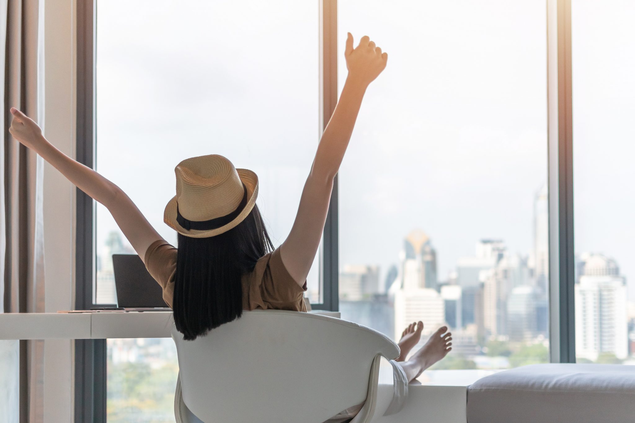 A girl is relaxing by sitting on her sofa in front of her window view