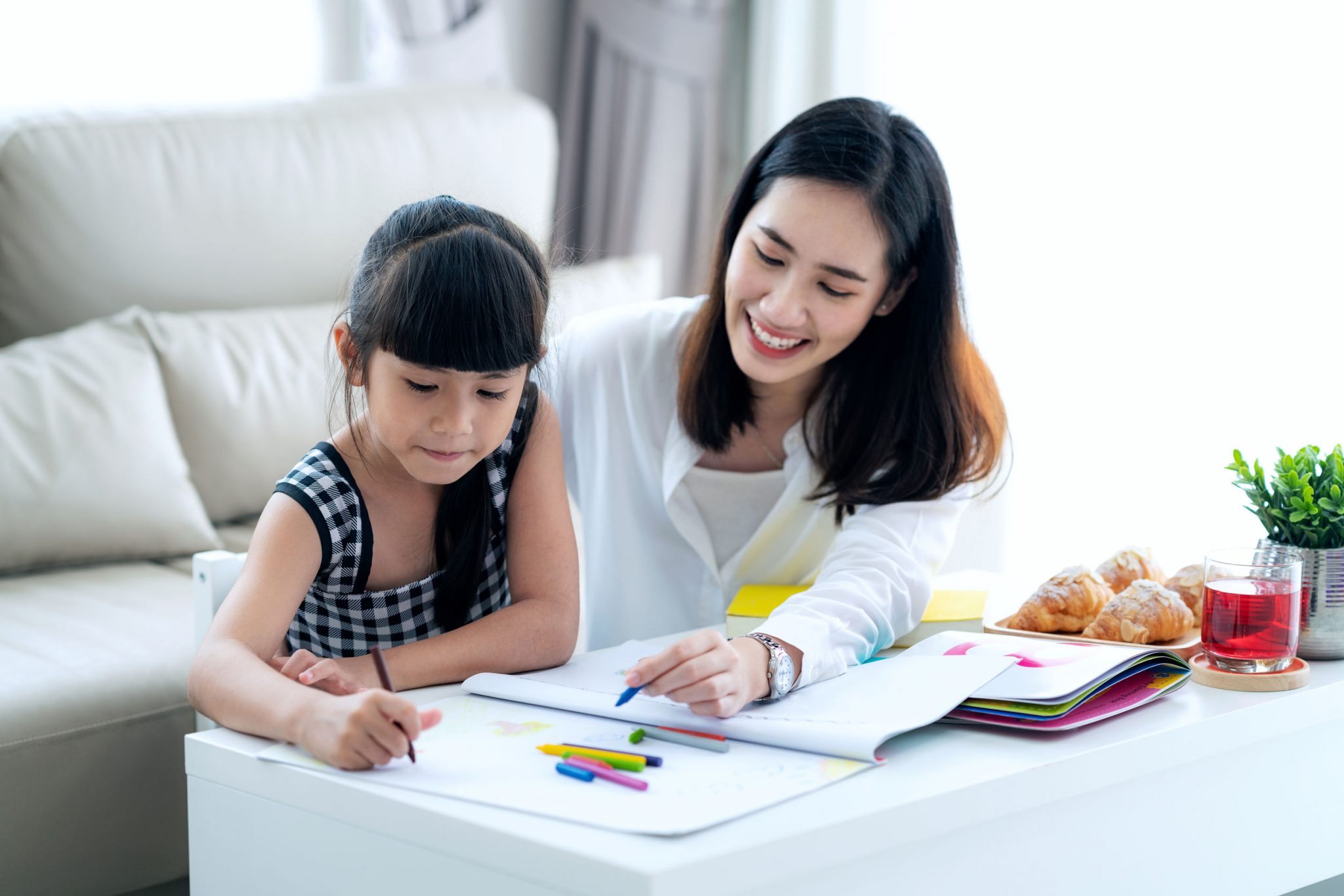 A mother assisting her female child in her study